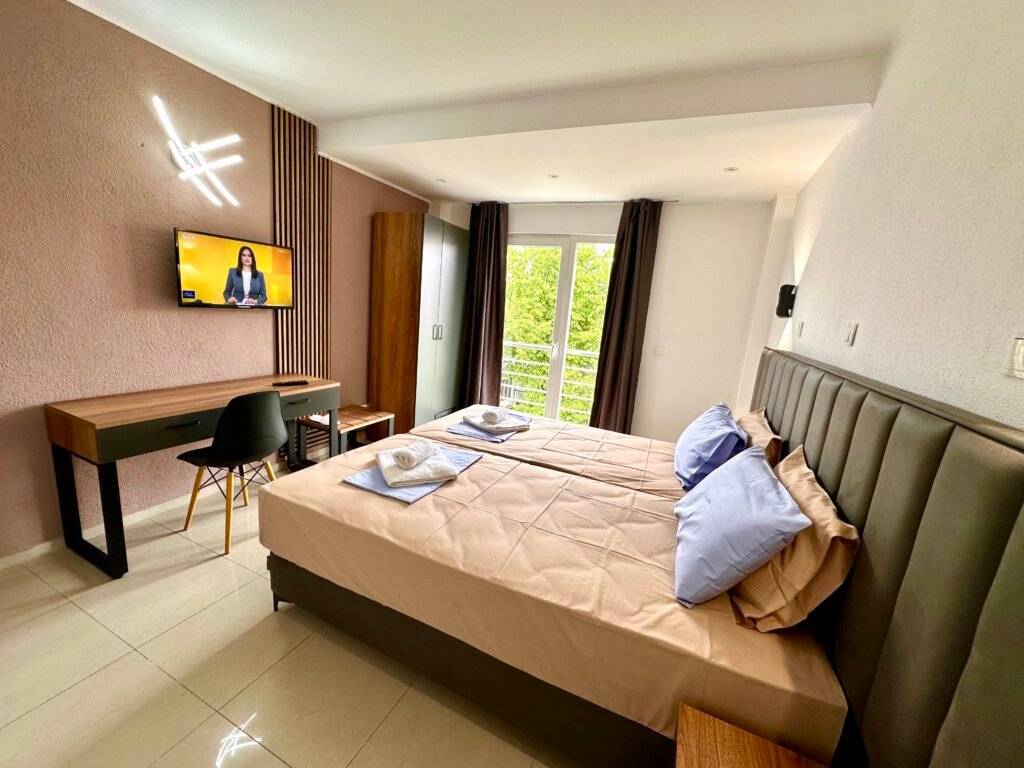Standard double room with balcony access and a wall-mounted TV