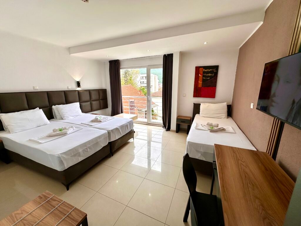Superior triple room with beds, a desk and balcony access