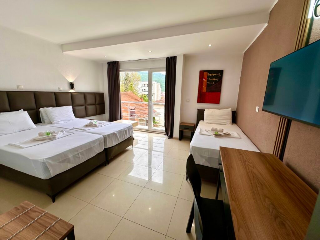 Superior triple room with a wall-mounted TV and balcony