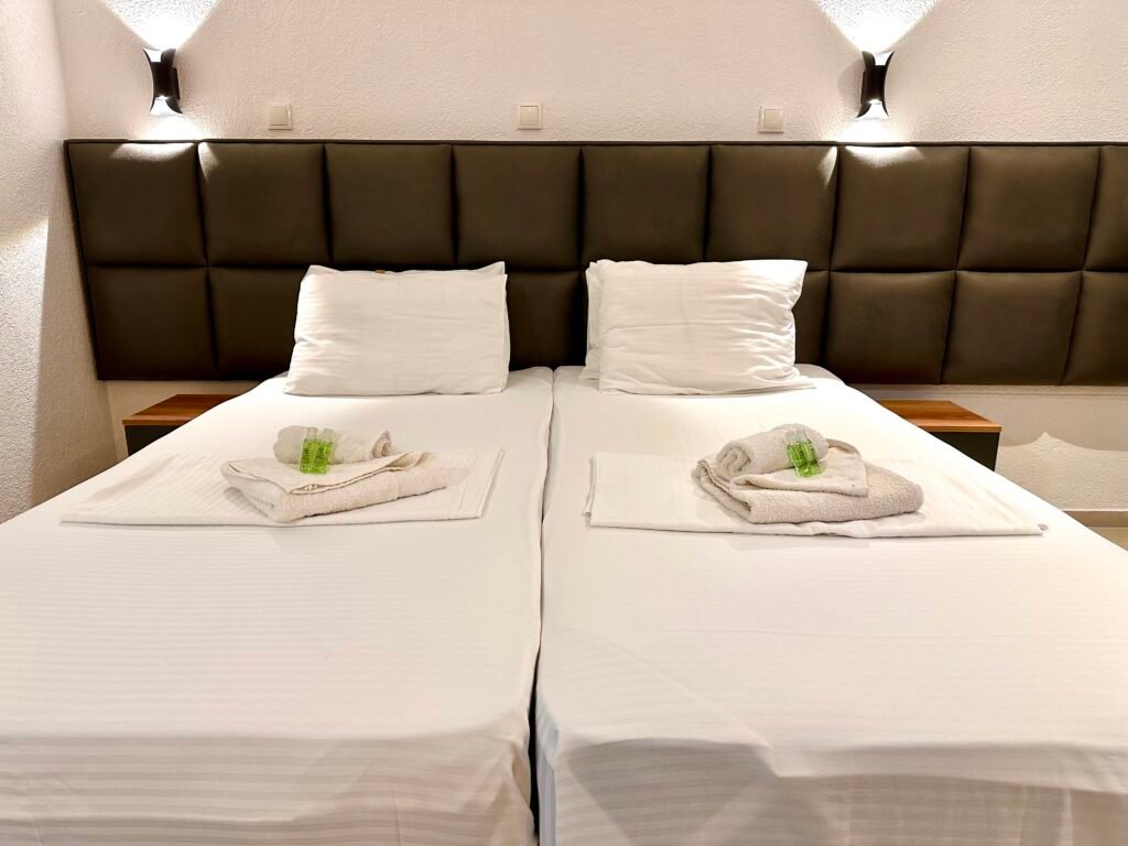 Made bed with white linen and folded towels in a Superior room